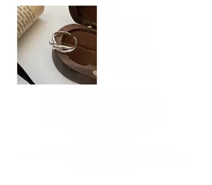 Detail of silver S925 interlocking cross ring displayed in a premium wooden jewelry box