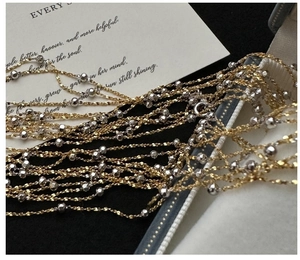 Gros plan détaillé du collier multicouche or et argent avec perles facettées brillantes