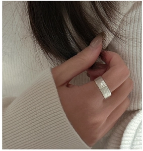 Détail de la bague large en argent avec trois perles et texture brossée sur fond en tricot
