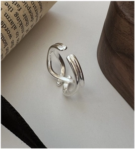 Detailed view of S925 sterling silver crossover ring on a vintage newspaper background