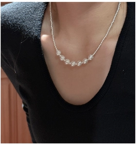 Detail shot of 925 sterling silver beaded necklace with hollow spherical charms on a model
