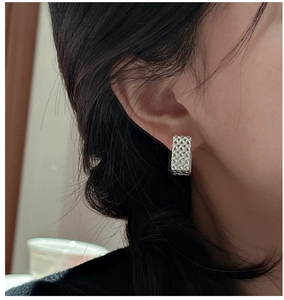 Gros plan détaillé de boucles d'oreilles en argent S925 avec texture tissée