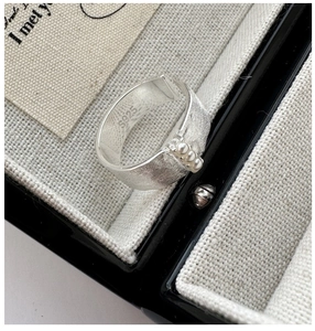 Vue macro de la bague en argent sterling S925 avec texture brossée et trois perles