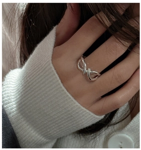 Close-up of S925 sterling silver ring with minimalist crisscross texture on finger
