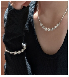 Detail of 925 sterling silver beaded necklace and bracelet set on female model