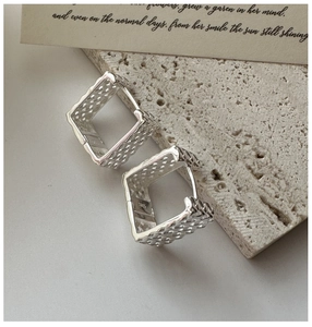 Vue macro de boucles d'oreilles créoles S925 en argent sterling avec maille creuse