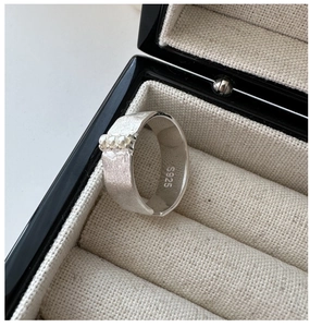 Détail d'une bague en argent sterling S925 avec texture brossée et trois petites perles