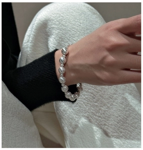 Makroaufnahme des S925 Silberperlenarmbands mit funkelnder Textur am Handgelenk getragen