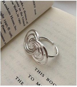 Macro shot of silver minimalist S925 sterling silver multi-layer spiral ring on a book