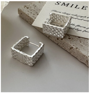 Vue détaillée macro des créoles carrées en argent sterling S925 avec texture tressée
