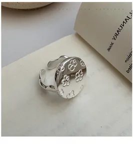 Close-up of S925 sterling silver flower ring with intricate hollow floral engravings