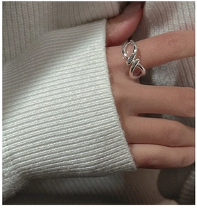 Macro detail of silver twisted line ring with knot design on woman's hand