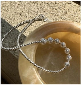Macro detail of 925 sterling silver beaded necklace with textured CNC sparkle beads
