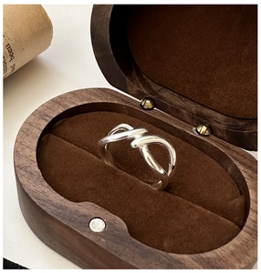 Detail of S925 silver overlapping line ring inside a premium vintage wood jewelry box
