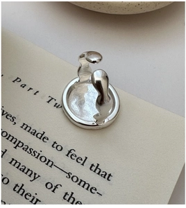 Detailed view of an organic curved silver ring on a vintage book background