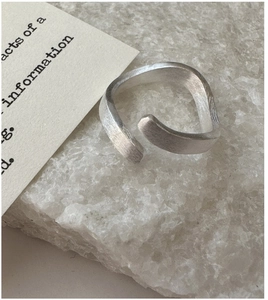 Close-up of S925 sterling silver ring with brushed texture and wavy minimalist design