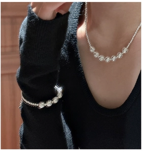 Detailed view of silver CNC flash bead necklace and bracelet set on a female model