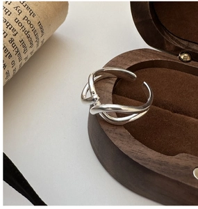Detail of S925 silver ring featuring a crossed-line texture on a vintage wood display