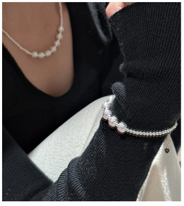 Macro detail of S925 silver bracelet featuring pavé zircon beads and heart pendant