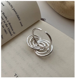 Detailed macro shot of S925 sterling silver multi-layered spiral ring on a vintage book