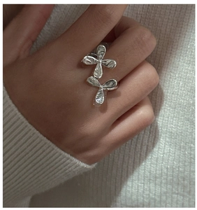 Detail of S925 sterling silver floral ring with hammered texture on model hand