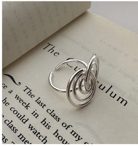 Detail of layered S925 sterling silver minimalist rings placed on an open book