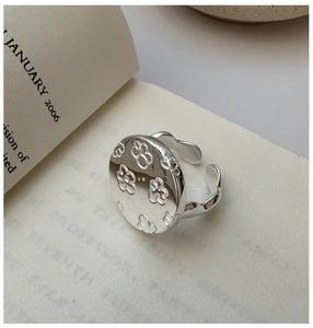 Macro detail of S925 sterling silver vintage flower ring on a minimalist book background