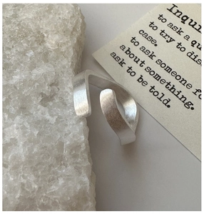 Detailed close-up of a minimalist S925 silver wave ring with a brushed matte texture finish