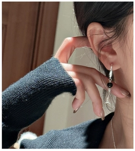Close-up of elegant S925 silver long drop earrings with black bead and glass bell charms
