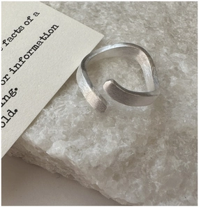 Close-up of S925 sterling silver ring with brushed texture and organic wave design
