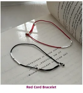 Minimalist red and black braided cord bracelets with S925 silver beads on a book page