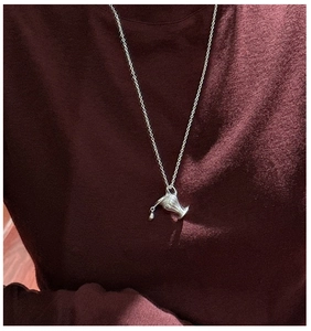 Detailed close-up of a S925 sterling silver watering can pendant with a small water drop detail