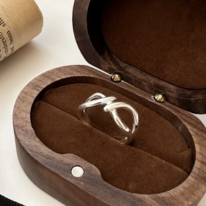 Polished S925 sterling silver infinity knot ring inside a vintage wooden jewelry box