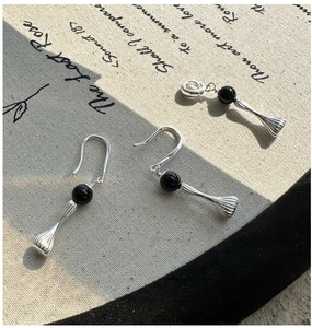 Detail of S925 silver earrings and pendant with black stones and grooved textures