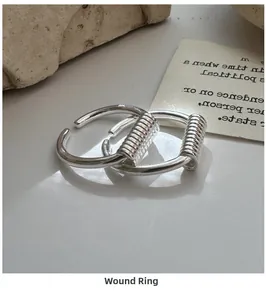Detail shot of a silver S925 wrap ring with industrial metal wire winding and open band