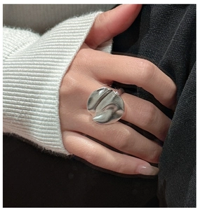 Detailed close-up of a sterling silver ring with irregular liquid metal texture design