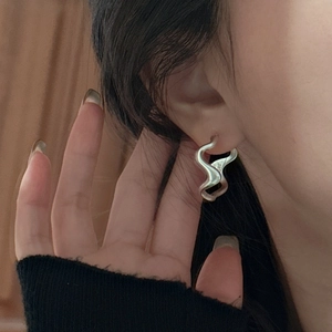 Minimalist S925 sterling silver hoop earrings with wave texture worn by a model