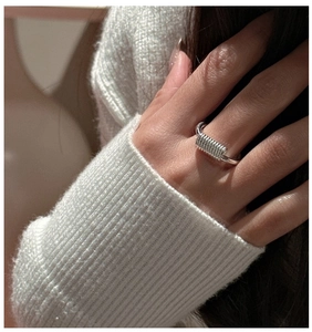 Detailed view of an S925 sterling silver ring with unique spring coil design on finger
