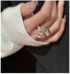 Detailed view of an irregular wave design S925 silver ring worn on a model's finger