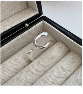 Macro shot of minimalist silver irregular curved open ring with polished metal finish