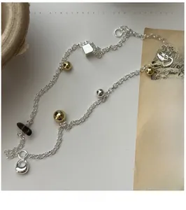 Macro detail of S925 silver necklace featuring smoky quartz and geometric metal beads