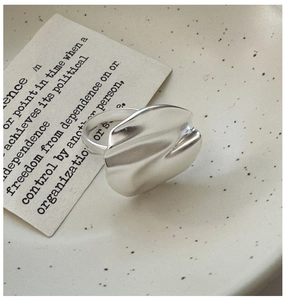 Macro view of matte S925 sterling silver ring with irregular organic wave design on ceramic
