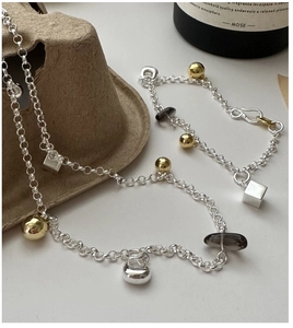 Detail of S925 silver bracelet featuring golden spheres and brown smoky quartz charms