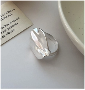 Macro detail of matte S925 sterling silver ring with irregular textured petal design