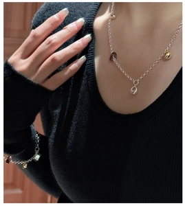 Detail of S925 silver necklace with tea crystal and geometric pendants on model