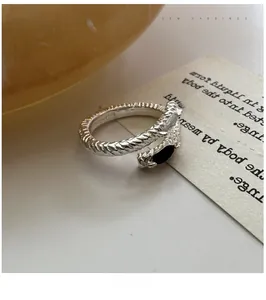 Detail of S925 sterling silver crossover ring with black teardrop gemstone and zircon