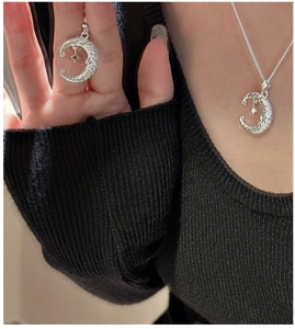 Detail of S925 sterling silver crescent moon necklace with a small hanging star charm