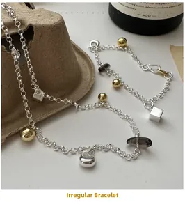 Détail du bracelet en argent S925 avec quartz fumé géométrique et breloques bicolores