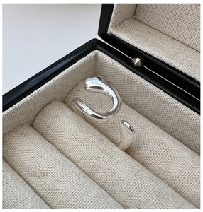 Macro shot of silver minimalist wavy ring displayed in a luxury jewelry storage box
