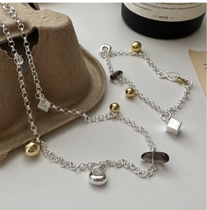 Macro detail of S925 silver bracelet with geometric charms and dark smoky quartz beads